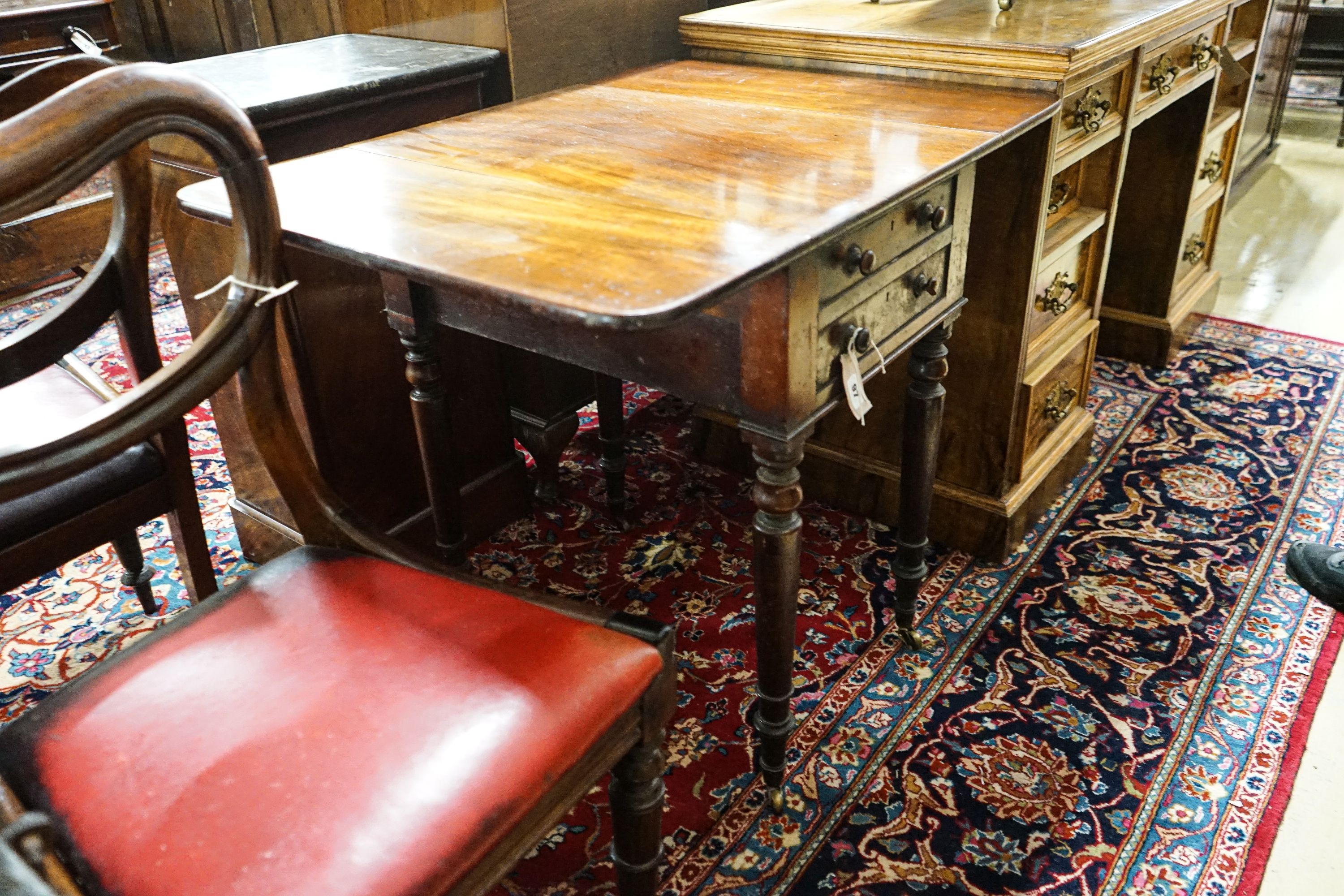 An early Victorian mahogany Pembroke work table, with twin flaps, two drawers, on turned legs and castors, 85cm extended, depth 61cm, height 70cm